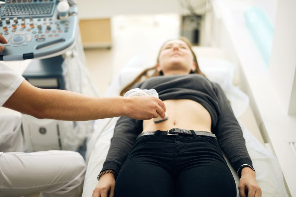 gynecologist scanning the stomach of the client