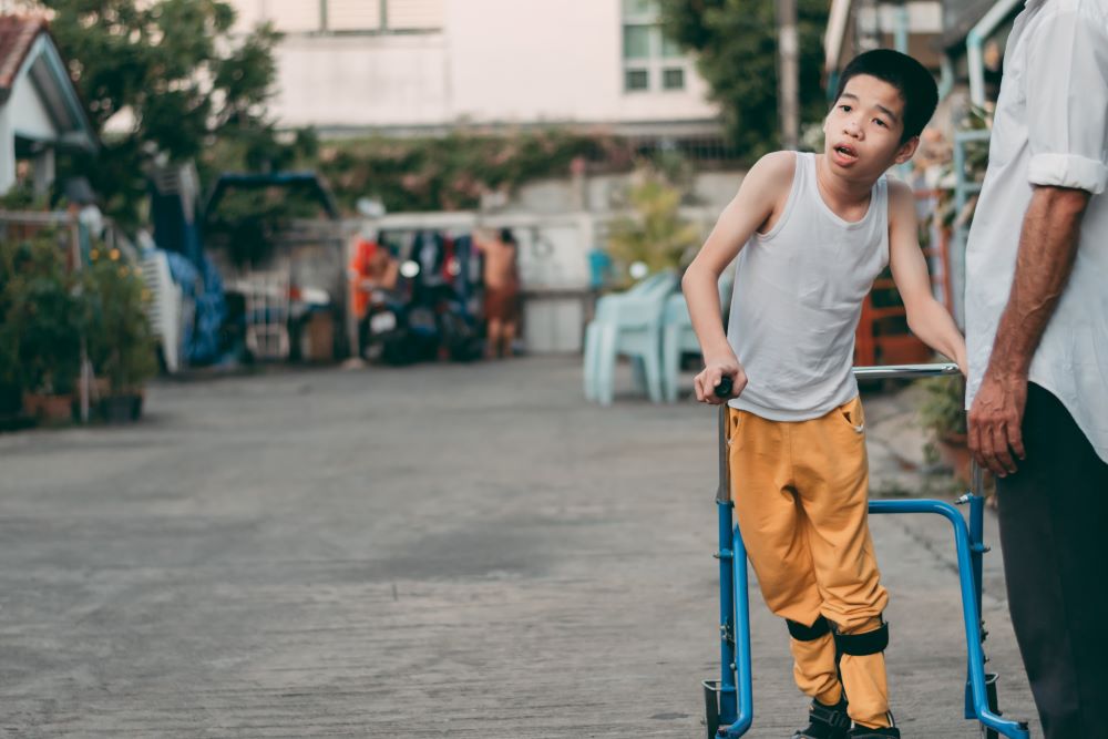 Disabled child training to walk by parent